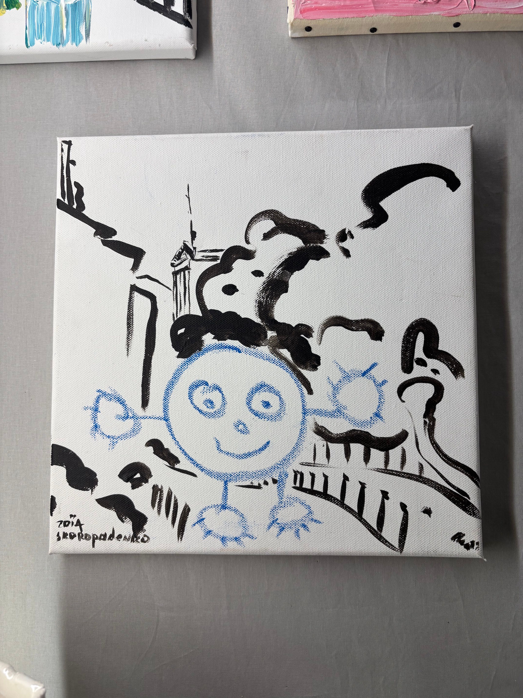 Original painting of a blue round figure with spiky hands in front of a black drawing of a columned building and rocks, signed Zoia Skoropadenko